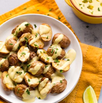 Roasted potatoes drizzled with vegan queso.